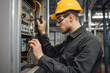 © kossovskiy - Electrician repairing electrical panel indoors