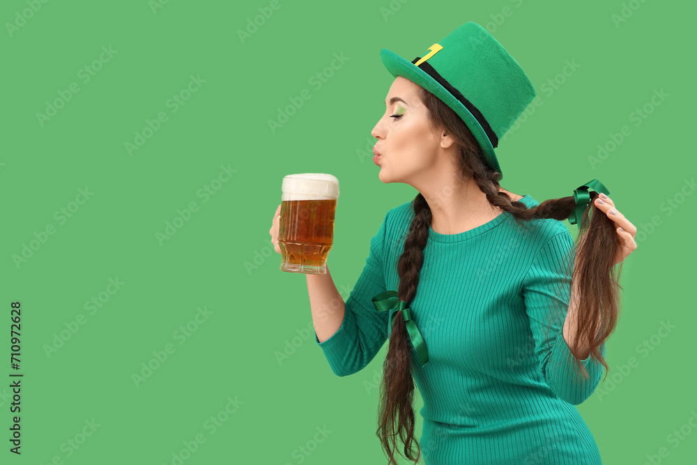 Young woman with beer on green background. St. Patrick's Day