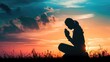 Silhouette of woman kneeling down praying for worship God at sky background. Christians pray to jesus christ for calmness. In morning people got to a quiet place and prayed. copy space