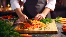 Closeup of a celebrity chefs precise knife skills as they julienne carrots for a live streamed cooking tutorial.