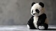 Close-up of a plush panda toy sitting on a textured surface