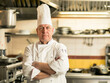 © koala studio - Portrait of senior male chef standing with arms crossed in restaurant kitchen
