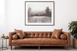 A leather couch sits in front of a black and white photo of a foggy forest.