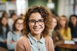 © duyina1990 - Portrait of a smiling young female student with curly hair wearing glasses in a classroom