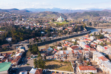 Wall Mural - View from drone of historical districts of old Georgian city of Kutaisi on both sides of Rioni river with rebuilt building of Cathedral 