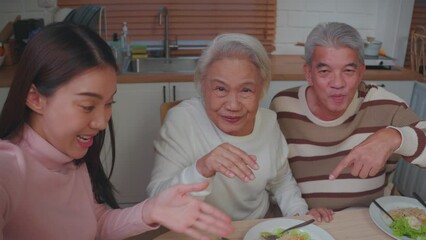 Wall Mural - Asian family doing video call while having lunch in house together. 