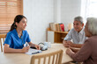 Asian caregiver nurse examine senior man and woman patient at home. 