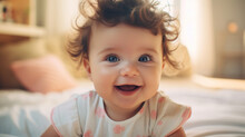A Baby With Big Blue Eyes And Curly Hair Smiles Brightly In A Sunlit Room, Creating An Image Of Innocence And Joy.