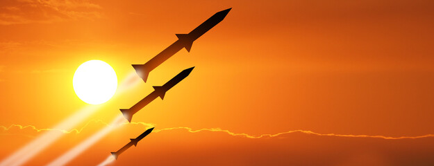 Wall Mural - Fired missiles fly to the target. Missiles at the sky at sunset. Missile defense. Rockets attack concept.