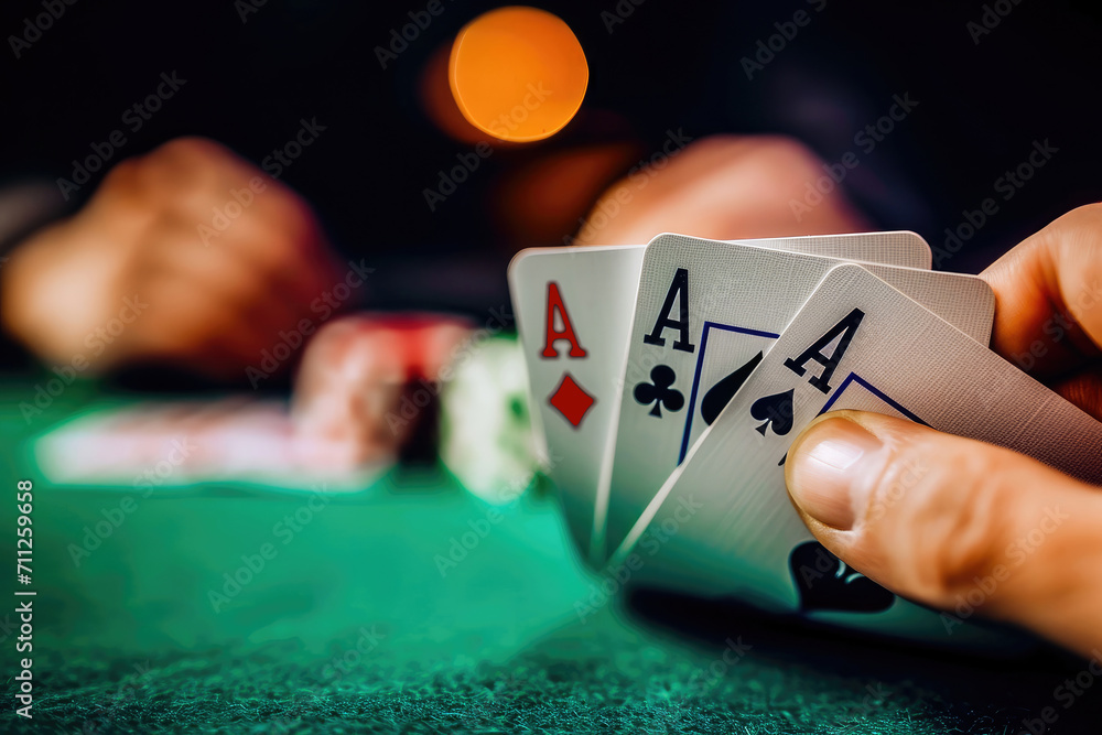 Close-up of a player's hand revealing a pair of aces during a high-stakes poker game in a casino setting.
