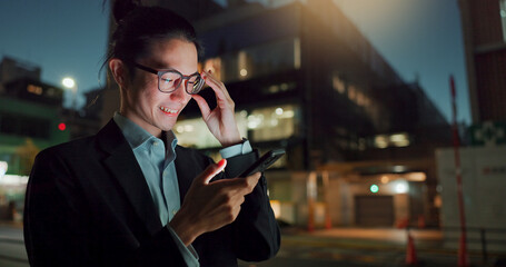 Phone, night and Asian businessman in the city networking on social media, mobile app or internet. Technology, smile and young professional male person with cellphone for research in town at night.
