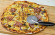 Pizza hawajska z boczkiem ananasem i pieczarkami z nożem do pizzy
