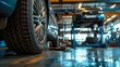 Close-up of a modern car tire in a well-equipped auto repair shop with vehicles being serviced in the background, highlighting automotive maintenance and care
