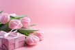 pink tulips and gifts on pink background