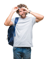 Canvas Print - Handsome hispanic student man wearing backpack and glasses over isolated background doing ok gesture with hand smiling, eye looking through fingers with happy face.