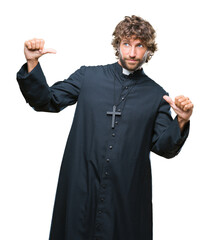 Canvas Print - Handsome hispanic catholic priest man over isolated background looking confident with smile on face, pointing oneself with fingers proud and happy.