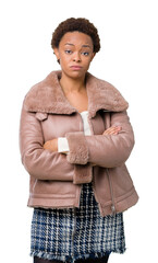 Sticker - Young african american woman wearing winter coat over isolated background skeptic and nervous, disapproving expression on face with crossed arms. Negative person.