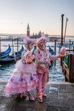 Fototapeta Big Ben - Colorful carnival masks at a traditional festival in Venice against gondolas, Italy