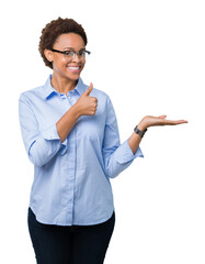 Young beautiful african american business woman over isolated background Showing palm hand and doing ok gesture with thumbs up, smiling happy and cheerful