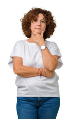 Poster - Beautiful middle ager senior woman wearing white t-shirt over isolated background looking confident at the camera with smile with crossed arms and hand raised on chin. Thinking positive.