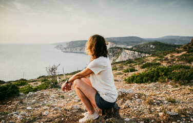 Wall Mural - woman tourist relaxing and watching rocks in the sea