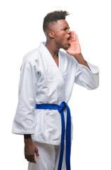 Sticker - Young african american man over isolated background wearing kimono shouting and screaming loud to side with hand on mouth. Communication concept.