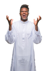 Sticker - Young arabic african man wearing traditional djellaba over isolated background celebrating mad and crazy for success with arms raised and closed eyes screaming excited. Winner concept