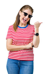 Poster - Middle age mature woman wearing sunglasses over isolated background smiling with happy face looking and pointing to the side with thumb up.