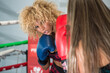 Boxing woman in activewear wearing boxing gloves on ring background fighting with opponent. Sport exercise, fitness workout.