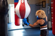 Boxing woman in activewear wearing boxing gloves on ring background fighting with opponent. Sport exercise, fitness workout.
