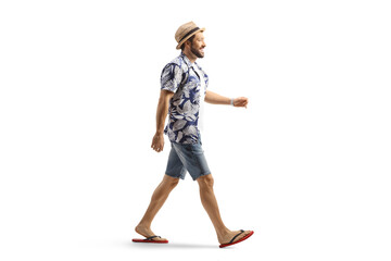 Wall Mural - Full length profile shot of a man in flip-flops and straw hat walking