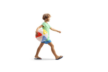 Poster - Full length profile shot of a boy walking and carrying a beach ball