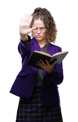 Young brunette student girl wearing school uniform reading a book over isolated background with open hand doing stop sign with serious and confident expression, defense gesture