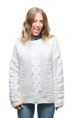 Poster - Beautiful young blonde woman wearing winter sweater over isolated background winking looking at the camera with sexy expression, cheerful and happy face.