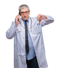 Sticker - Handsome senior doctor man talking on smarpthone over isolated background with angry face, negative sign showing dislike with thumbs down, rejection concept