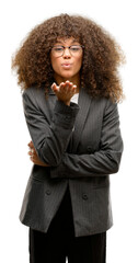 Canvas Print - African american business woman wearing glasses looking at the camera blowing a kiss with hand on air being lovely and sexy. Love expression.