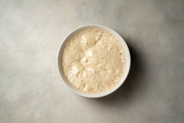 Wall Mural - Top view sourdough starter in a bowl. Home baking, wild east, fermented food.