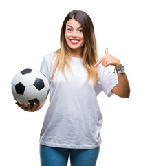 Sticker - Young beautiful woman holding soccer ball over isolated background with surprise face pointing finger to himself