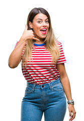 Wall Mural - Young beautiful woman casual look over isolated background smiling doing phone gesture with hand and fingers like talking on the telephone. Communicating concepts.