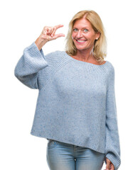 Sticker - Middle age blonde woman wearing winter sweater over isolated background smiling and confident gesturing with hand doing size sign with fingers while looking and the camera. Measure concept.