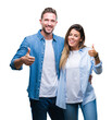 © Krakenimages.com - Young couple in love over isolated background doing happy thumbs up gesture with hand. Approving expression looking at the camera with showing success.