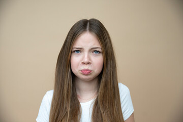 beautiful, cool, cute tween, teenager girl with long hair is posing in front of brown background