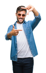 Sticker - Young handsome man wearing sunglasses over isolated background smiling making frame with hands and fingers with happy face. Creativity and photography concept.