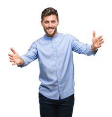 Canvas Print - Young handsome man over isolated background looking at the camera smiling with open arms for hug. Cheerful expression embracing happiness.