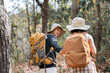 © itchaznong - Happy LGBT Lesbian couple Travelers Hiking with Backpacks in forest Trail. LGBT Lesbian Couple Hikers with backpacks walks in mountains in vacation
