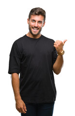 Wall Mural - Young handsome man over isolated background smiling with happy face looking and pointing to the side with thumb up.