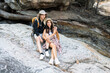 © itchaznong - Lesbian couple relaxing together on rock at a hiking trail While traveling together on a hiking trail
