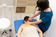© ADDICTIVE STOCK - Physiotherapist giving neck treatment to male patient
