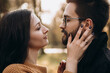 © Volodymyr - Heterosexual caucasian young loving couple walking outside in the city park in sunny weather, hugging smiling kissing laughing spending time together. Autumn, fall season, orange yellow red maple leav