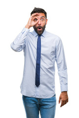 Canvas Print - Adult hispanic business man over isolated background doing ok gesture shocked with surprised face, eye looking through fingers. Unbelieving expression.